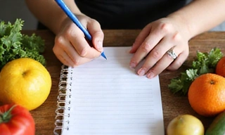 Persona escribiendo un plan de comidas saludable en un cuaderno